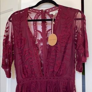 Burgundy v-neck romper with lace overlay.